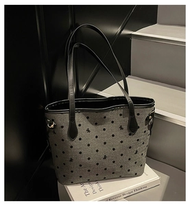 Détail du sac cabas gris à pois avec nœud brodé et boucles métalliques dorées élégantes
