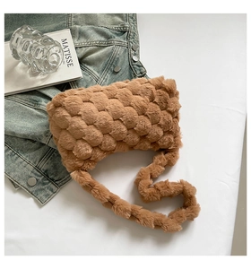 Detail of a large brown plush woven tote bag on denim, showing soft texture and cozy craft