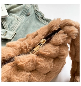 Detailed macro view of plush quilted faux fur bag with a gold metal zipper closure