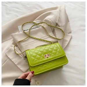 Detail of bright green quilted crossbody bag with gold chain strap and metal turn lock