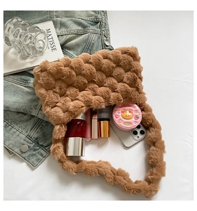 Top view of plush brown bag showing spacious interior with makeup and smartphone