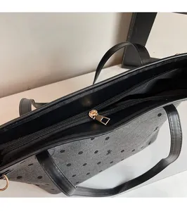Détail de la fermeture éclair dorée sur le sac cabas gris à pois en tissu