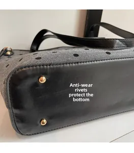 Gros plan du fond du sac cabas gris avec clous de protection dorés et motif à pois