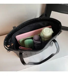 Détail de l'intérieur spacieux du cabas gris foncé montrant la capacité pour tablettes
