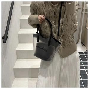 Détail d'un sac cabas noir en PVC semi-transparent avec lanières en cuir et pochette interne