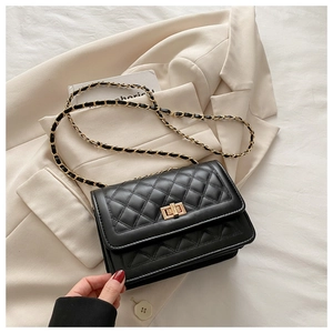 Detail of black quilted leather shoulder bag with gold twist lock and chain strap