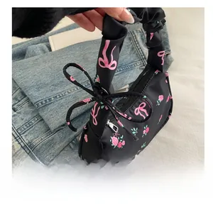 Detail of floral underarm bag with pink bow pattern and ruched handle design