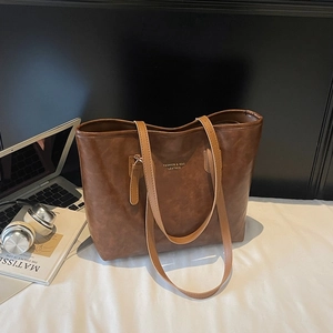 Brown faux leather tote bag with gold lettering and slim shoulder straps for women