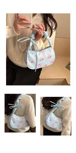 Detail of floral underarm bag with pink roses, bow prints, and ruched scrunchie strap