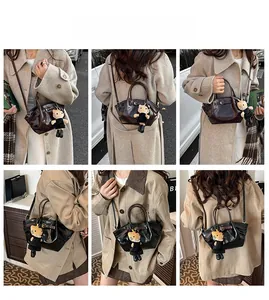 Detail showing mini faux leather tote bags in coffee and black with a cartoon charm