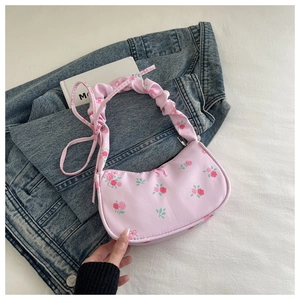 Detail of pink floral shoulder bag with ruched handle and vintage rose pattern
