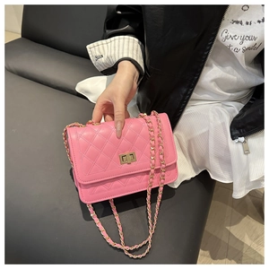 Detail of pink quilted shoulder bag featuring gold chain strap and metal turn-lock closure