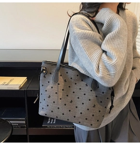 Détail du sac cabas gris à pois avec broderie de nœuds et anses en cuir noir robuste