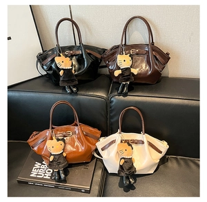 Detail of four matte vintage bucket bags in various colors with cute cat plush charms