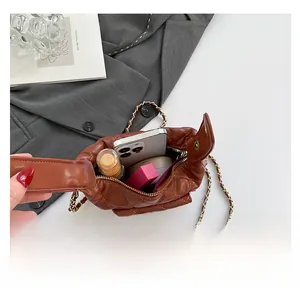Brown quilted crossbody bag interior capacity with smartphone, lipstick, and makeup
