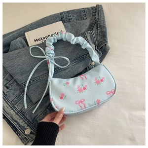Detail of light blue floral underarm bag with pink roses and ruffled cloud handle