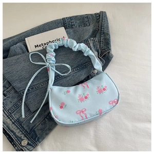 Detail view of light blue shoulder bag with pink roses and scrunchie handle design