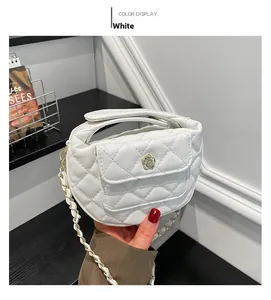 Close-up of white quilted leather handbag with gold camellia buckle and chain strap