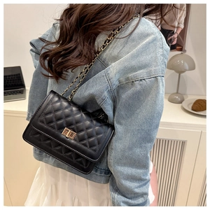 Detail of black quilted leather shoulder bag with gold twist lock and chain strap