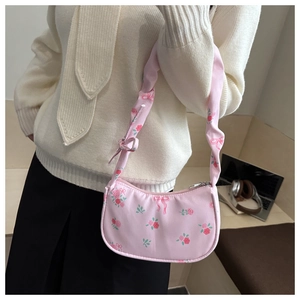 Detailed view of floral pink ribbon shoulder bag with pleated strap and zipper closure