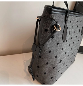 Détail du sac cabas à chevrons avec pois, nœud noir et poignées en cuir synthétique