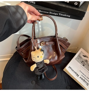 Detail of dark brown wax leather tote with adjustable strap and decorative metal buckle