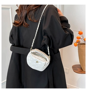 Close-up of a white quilted crossbody bag with gold-tone hardware and chain strap