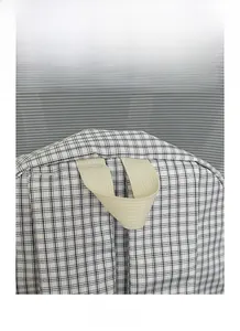 Detail view of the durable woven handle and black and white checkered fabric of the backpack