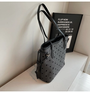 Détail du cabas en toile grise à pois noirs, motifs de nœuds et anses en cuir