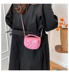 Detailed shot of pink quilted mini crossbody bag with golden floral metal buckle