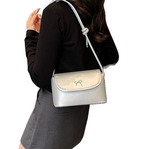 Silver metallic crossbody bag with bow buckle and knotted strap on white background