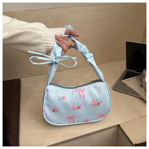 Detail of light blue canvas shoulder bag with pink roses and ruffled handle design