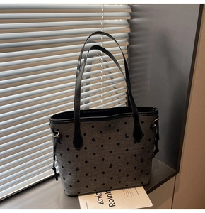 Détail du cabas en toile grise à pois noirs, motifs nœuds et anses en cuir noir