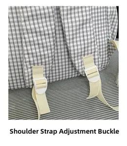 Detail of adjustable cream shoulder strap and white buckle on checkered backpack