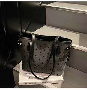 Détail du sac cabas gris à pois avec nœud noir et éléments en métal argenté élégants