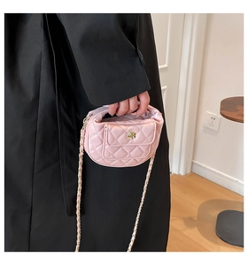 Detail of pink quilted mini bag with golden rose lock and chain strap on black coat