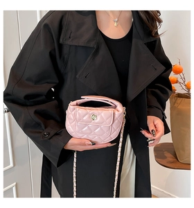 Detailed close-up of pink quilted leather crossbody bag with golden flower clasp