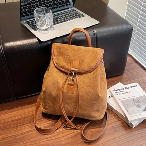 Sac à dos rétro en daim marron caramel avec cordon de serrage et poignée dans un décor chic