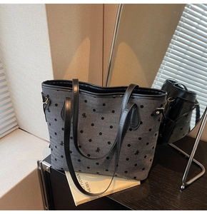 Détail du cabas gris foncé avec motifs à pois noirs, nœuds et bandoulières en cuir