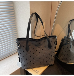 Détail du sac cabas en tissu gris avec pois noirs et fines bandoulières en cuir
