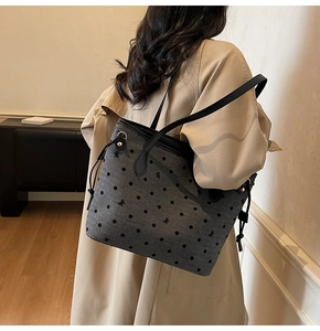 Détail du grand cabas en toile grise à pois noirs avec des anses en cuir élégantes