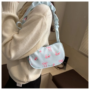 Detail of light blue floral baguette bag with pink bows and ruffled shoulder strap