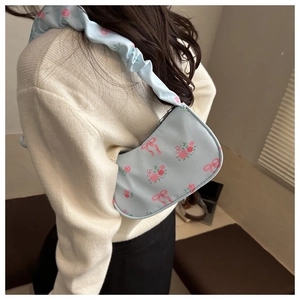 Floral hobo bag with pink roses and scrunchie strap shown on model's shoulder
