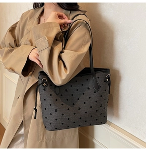 Détail d'un cabas gris foncé avec pois noirs et fines bandoulières en cuir élégantes