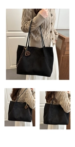 Detailed view of black suede tote bag with metallic B pendant on long leather straps