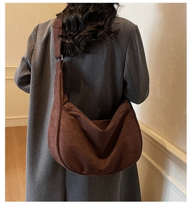Detailed texture of dark brown suede hobo bag worn with a charcoal winter coat
