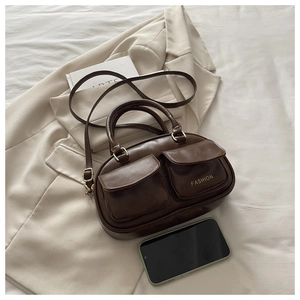 Detail of vintage brown PU leather bowling bag with gold hardware and side pocket