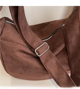 Detail of adjustable wide shoulder strap with silver buckle on a brown corduroy tote bag