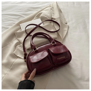 Detail of burgundy vintage bowling bag with front pockets and golden fashion text