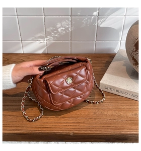 Detailed close-up of brown quilted leather bag featuring a silver sunflower metal clasp